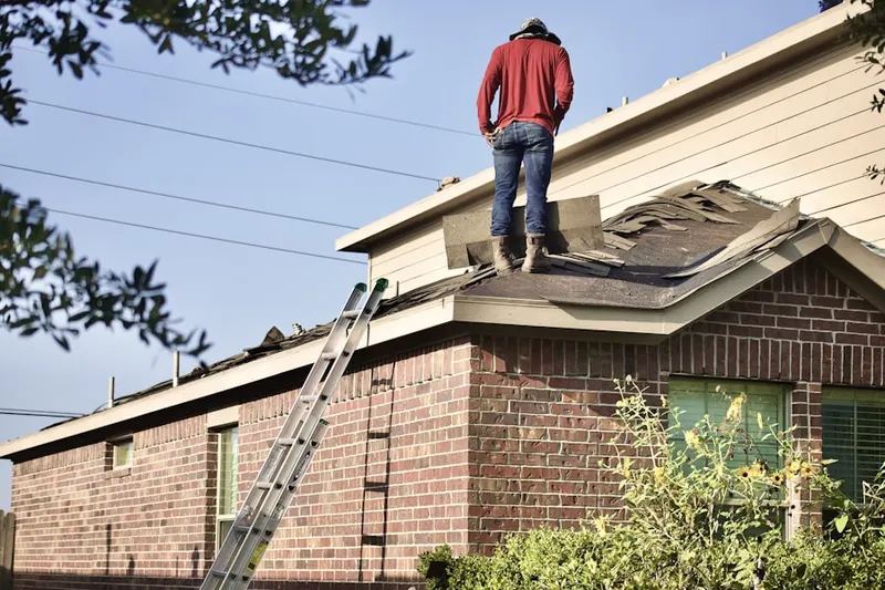 Professional roofer working on a residential roof in Wollochet